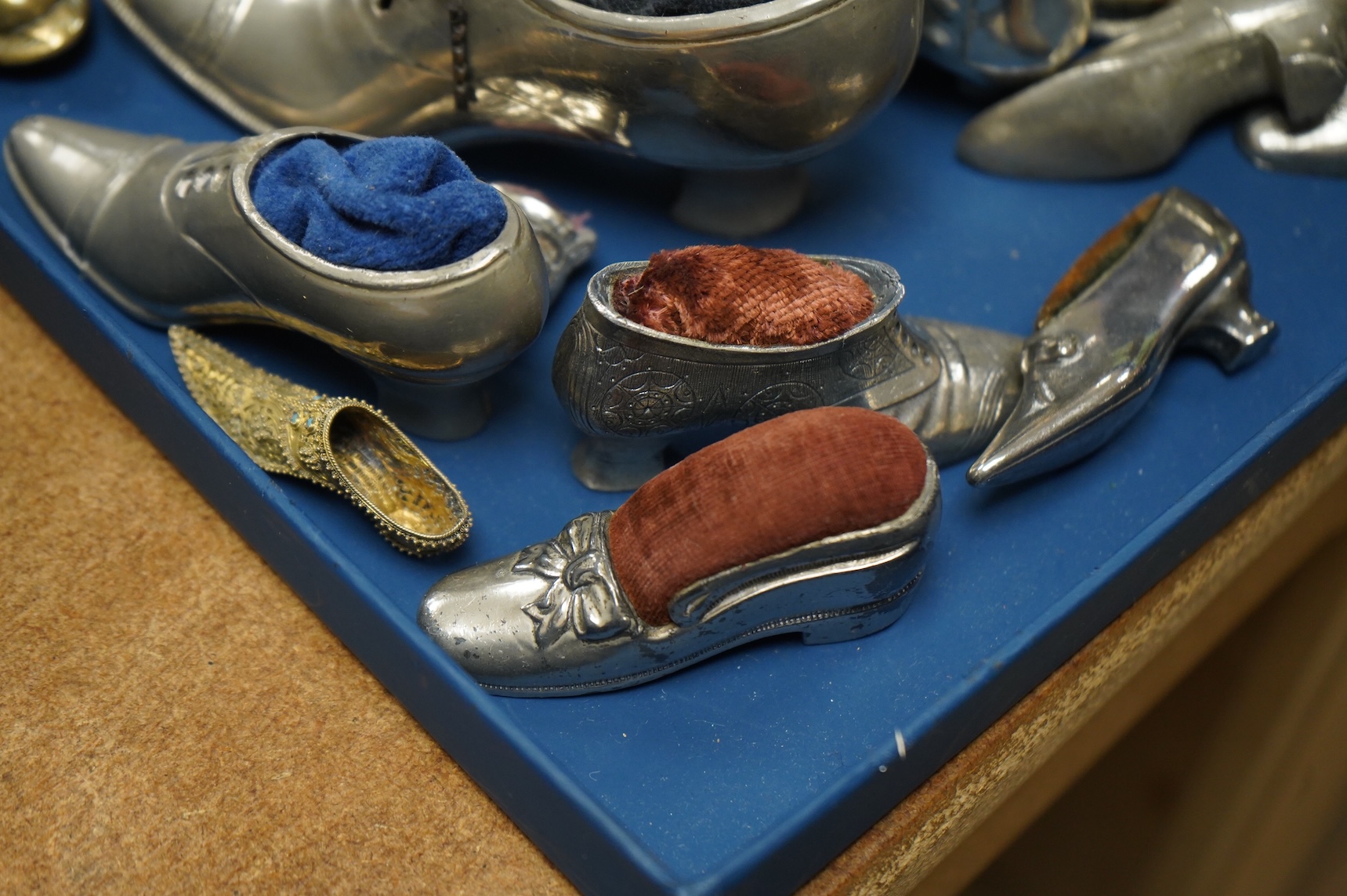 A collection of assorted miniature model shoes including pin cushions, one with modern silver mount